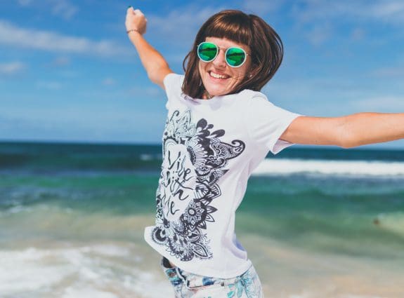 Happy person jumping on beach